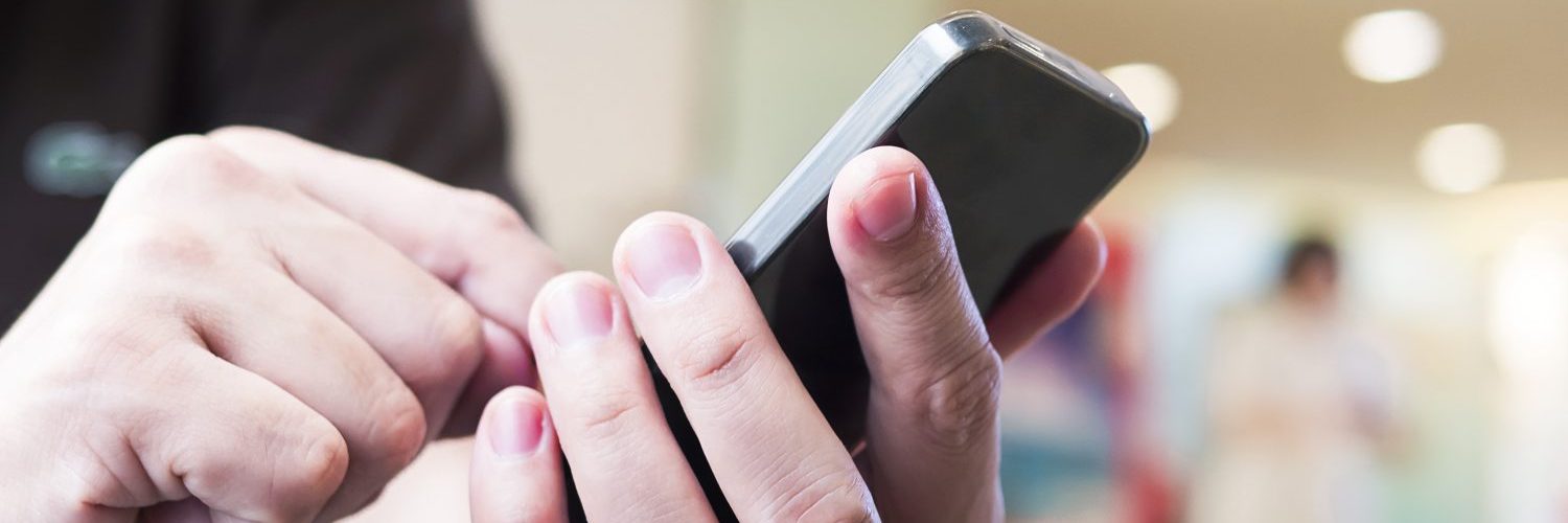 6295 A man is using telephone over colorful blurred bokeh light in office and people background