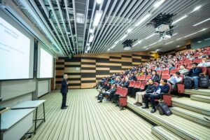 Man giving a presentation to a full lecture theater