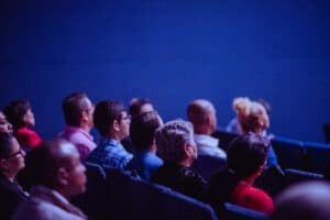 People sitting on chairs in a conference venue.