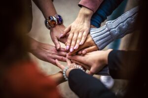 A group of people holding hands, forming a community 
