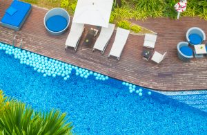 Aerial view of a resort pool deck with loungers and pool floats 